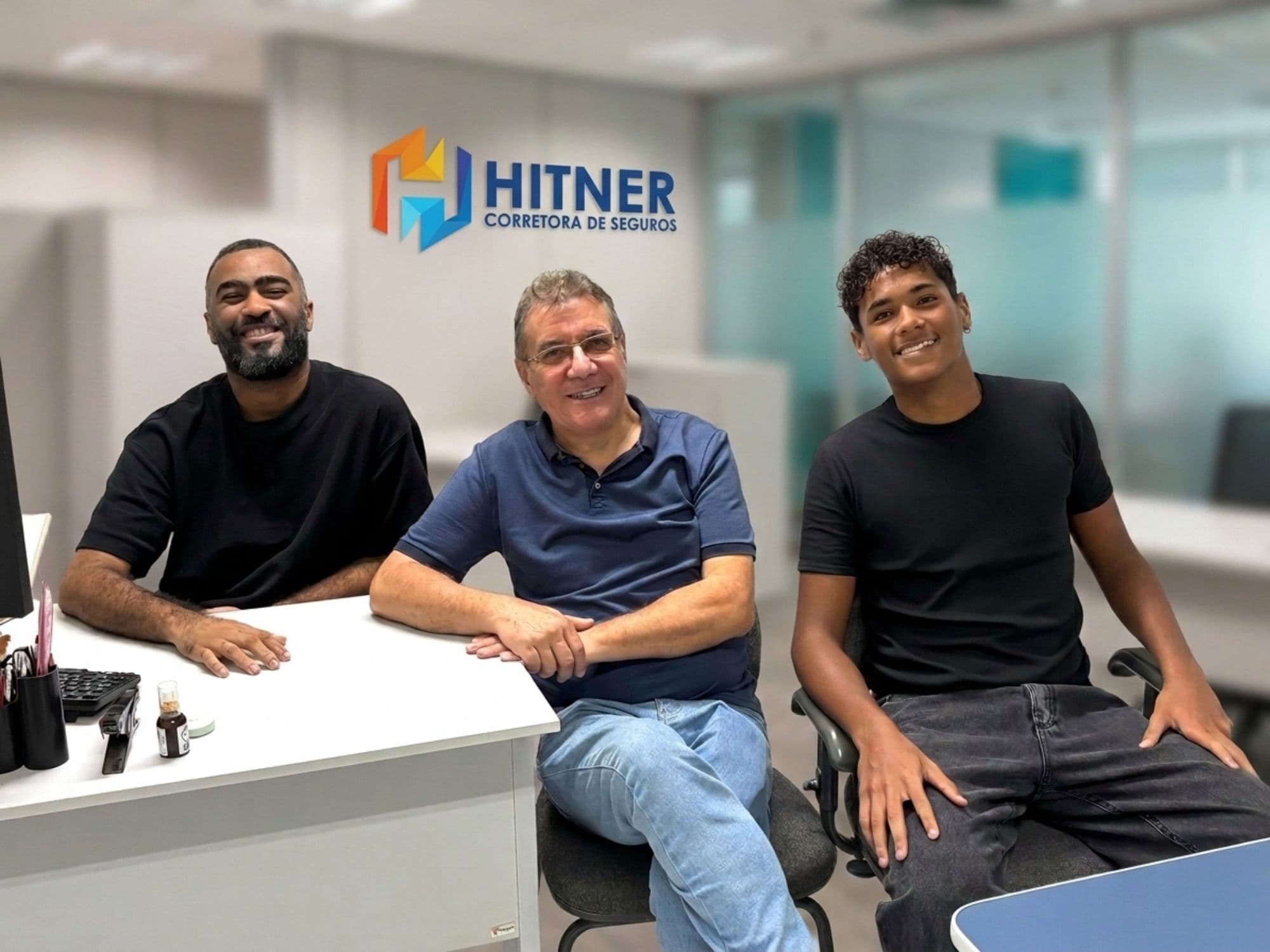 Equipe da Hitner reunida em mesa de trabalho no escritório em Salvador