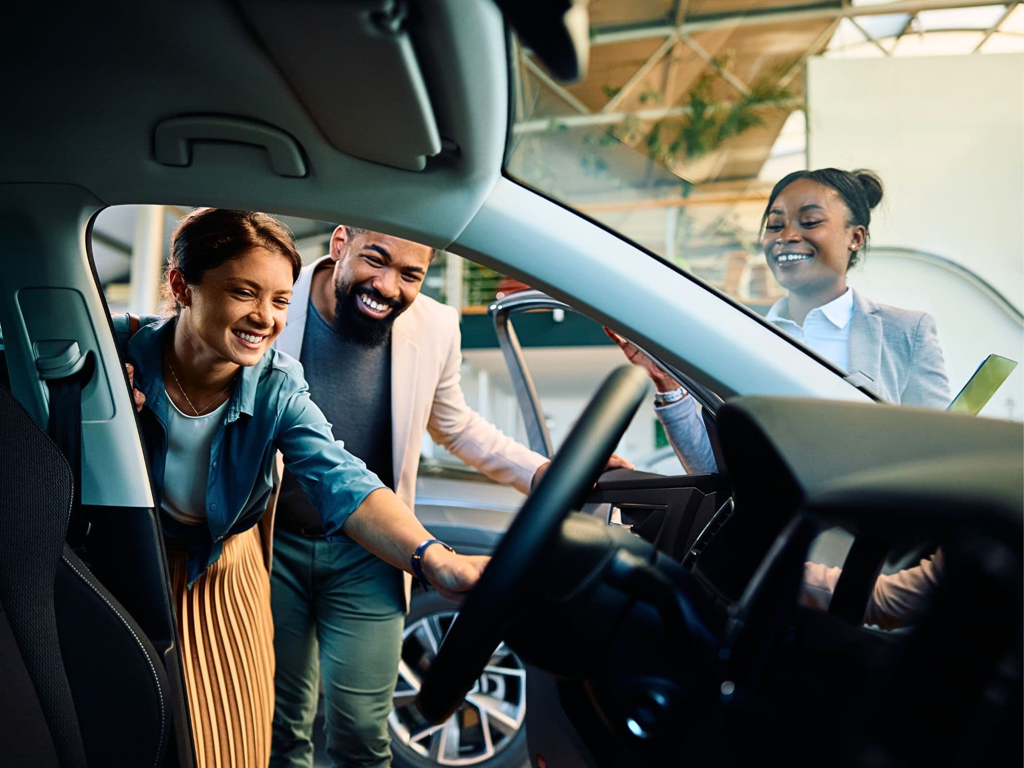 Grupo avaliando um carro na concessionária